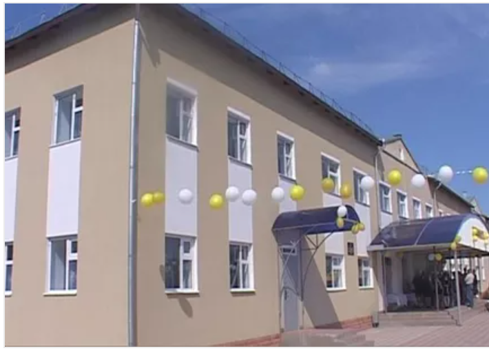 Two-story beige building with white and yellow decorations and a blue awning.