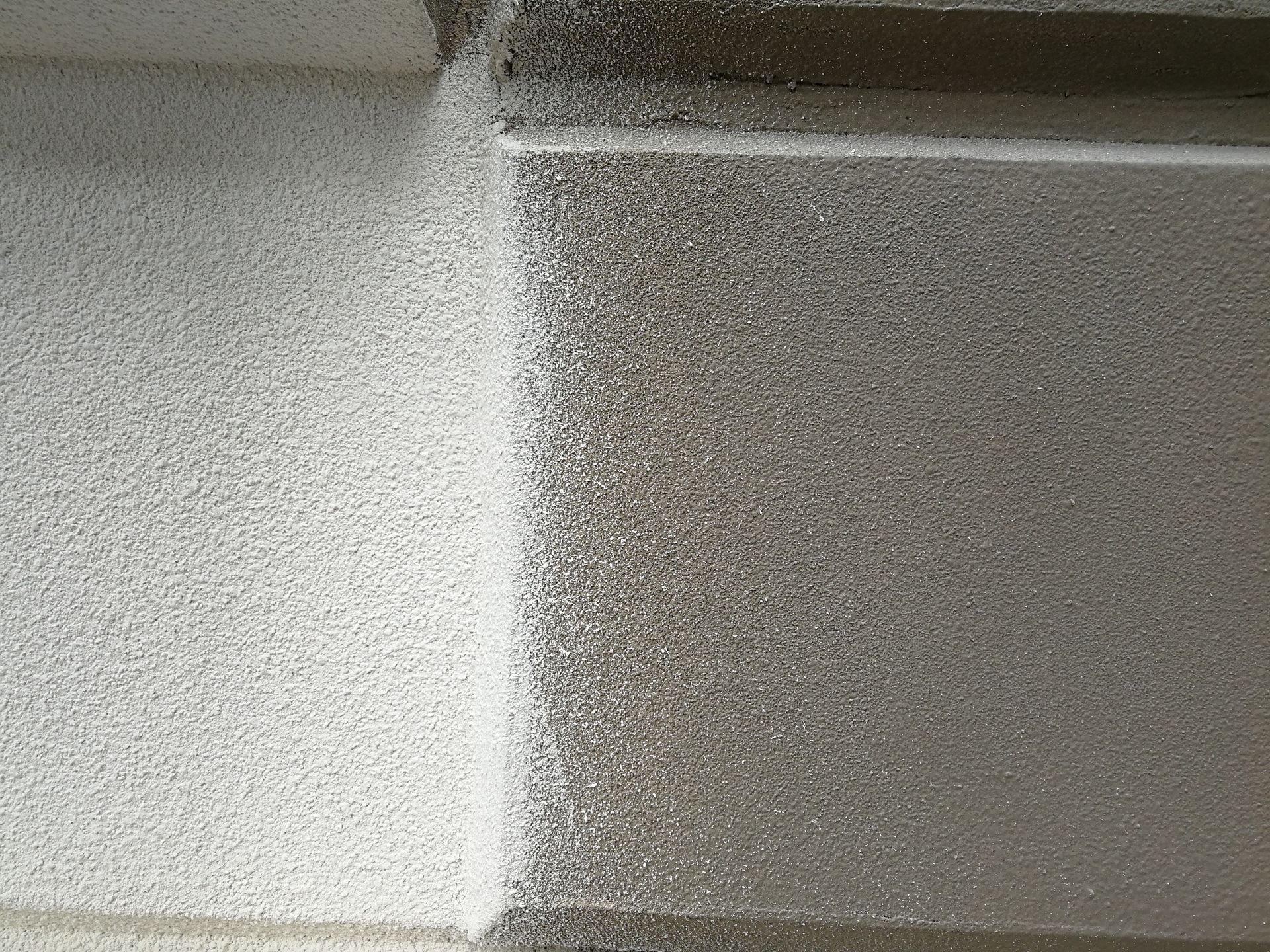 Textured, light-colored wall with a distinct, rectangular border, with a darker gray area.