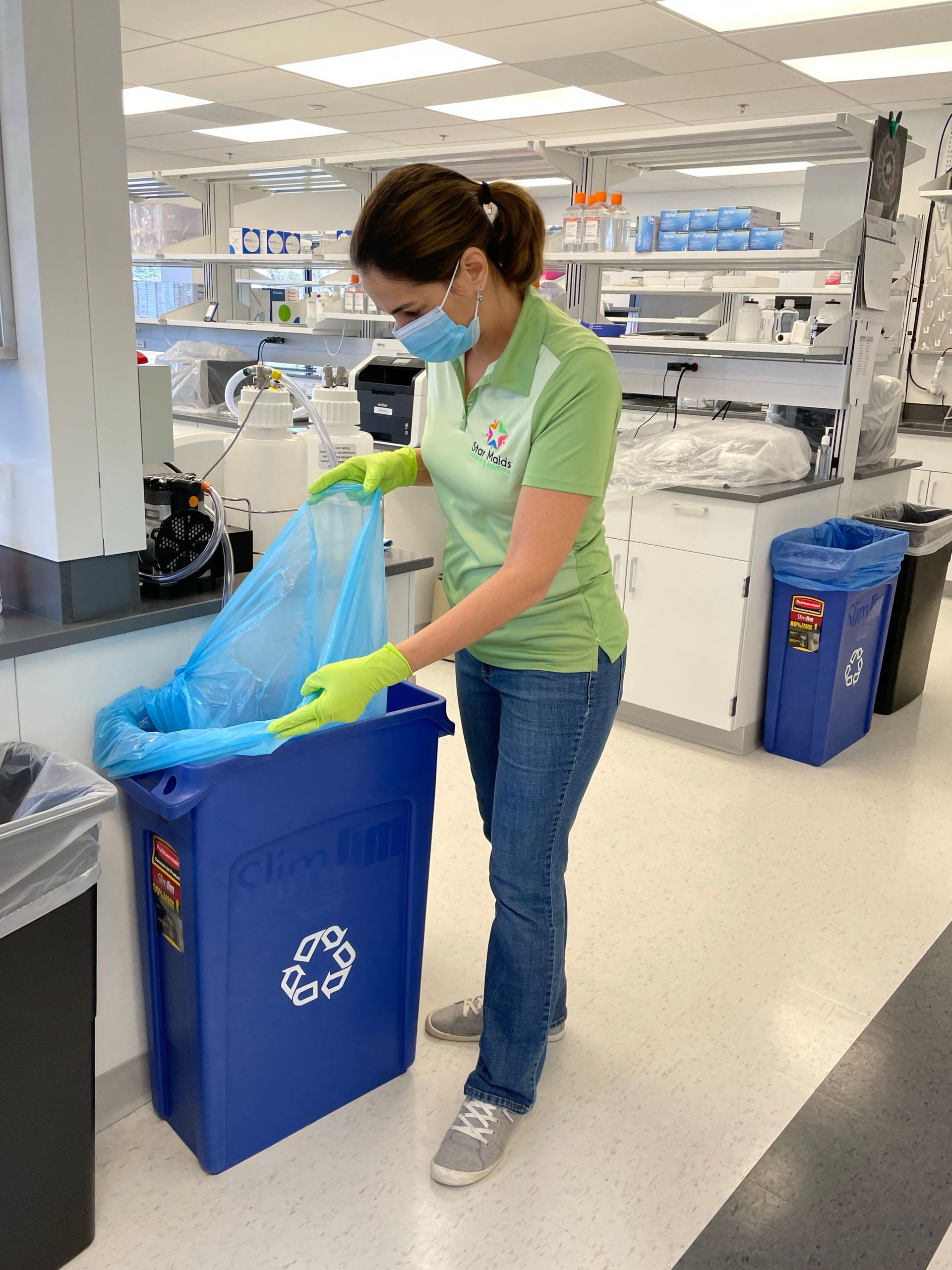 Mopping Floor - Olney, Maryland - Star Maids Cleaning Solutions LLC Person in a green shirt and gloves sorting recycling into a blue bin in a store aisle