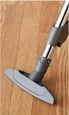 Vacuum cleaner nozzle on a wooden floor cleaning along the baseboard