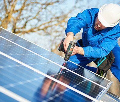 man installing solar panel on roof