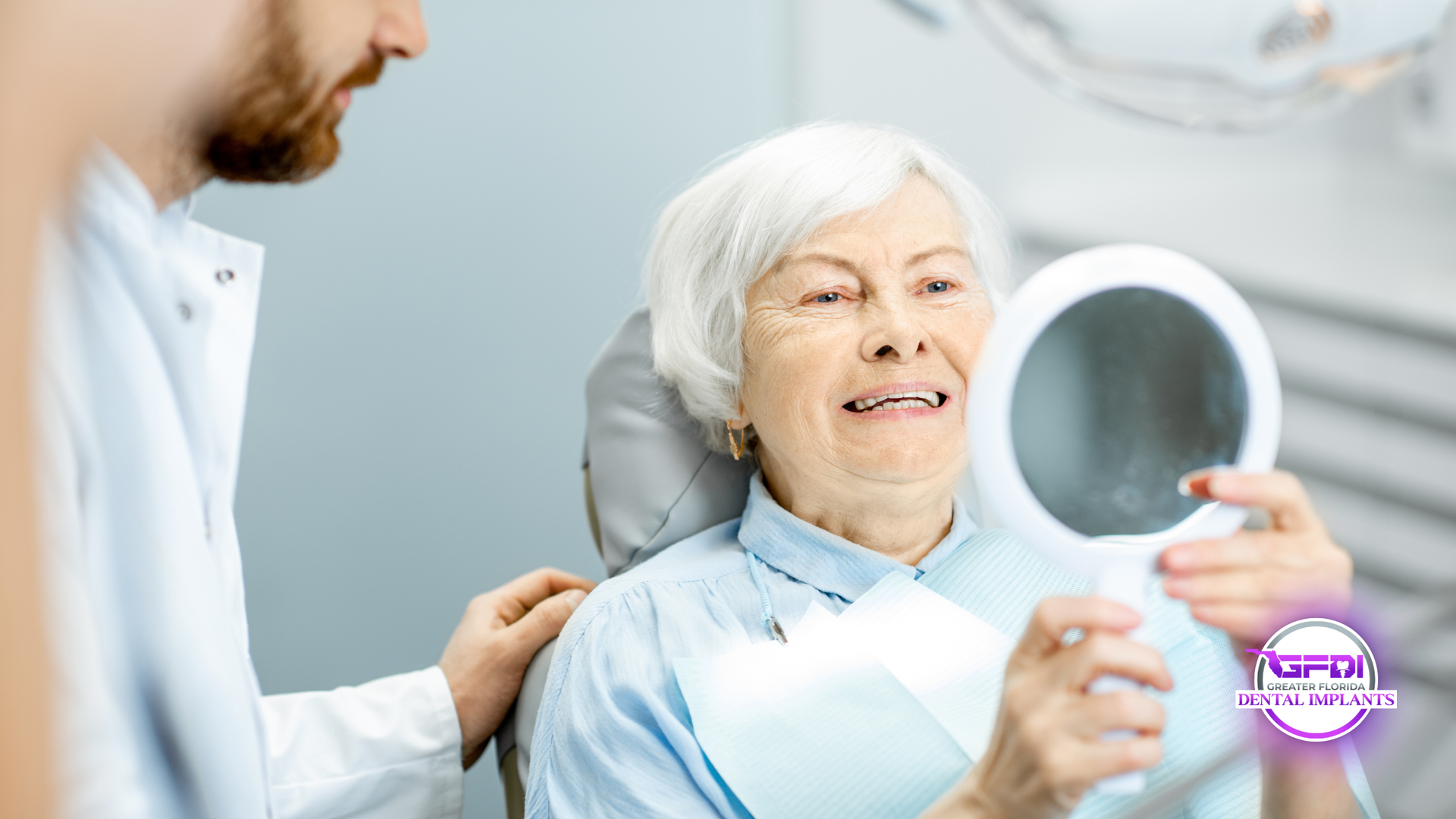 Dentist and patient in dental chair; patient smiles, holding a mirror.