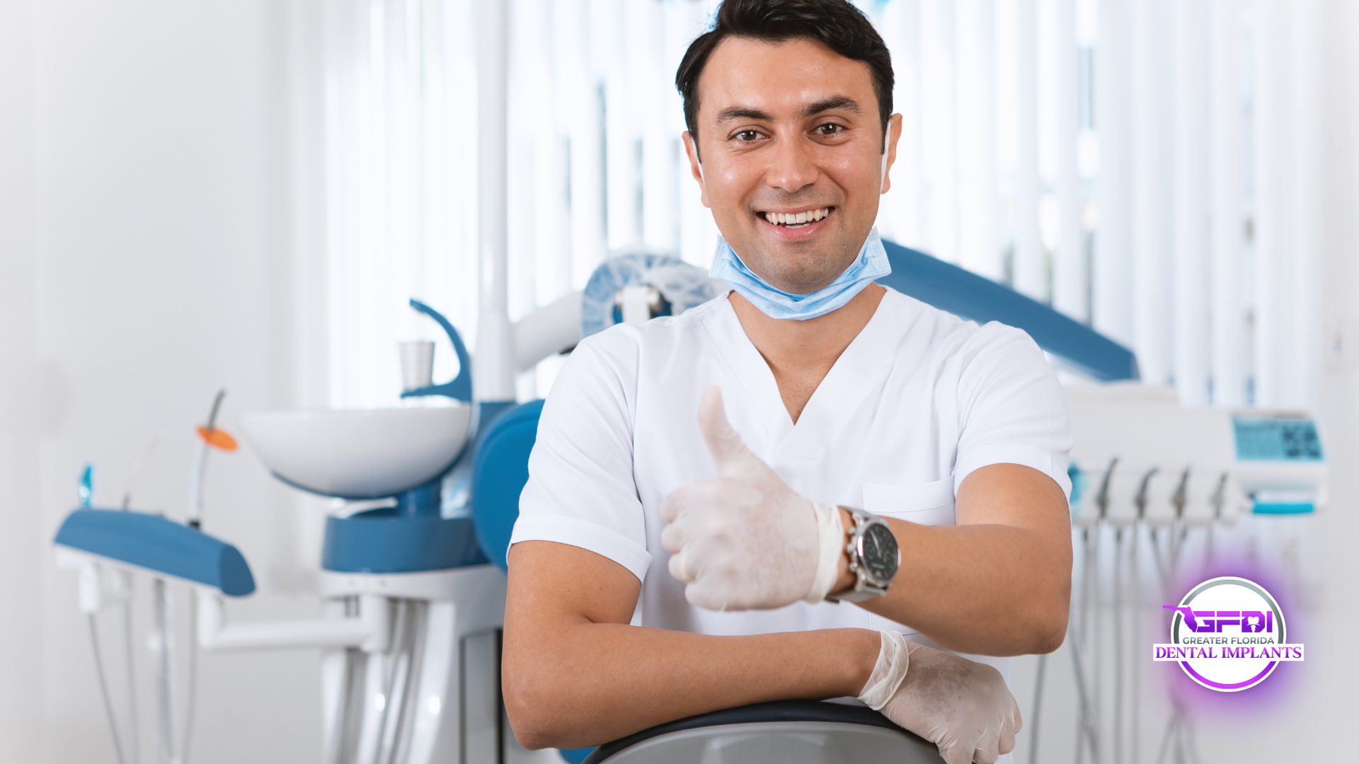 Dentist in white scrubs gives thumbs up, smiling in dental office with equipment.