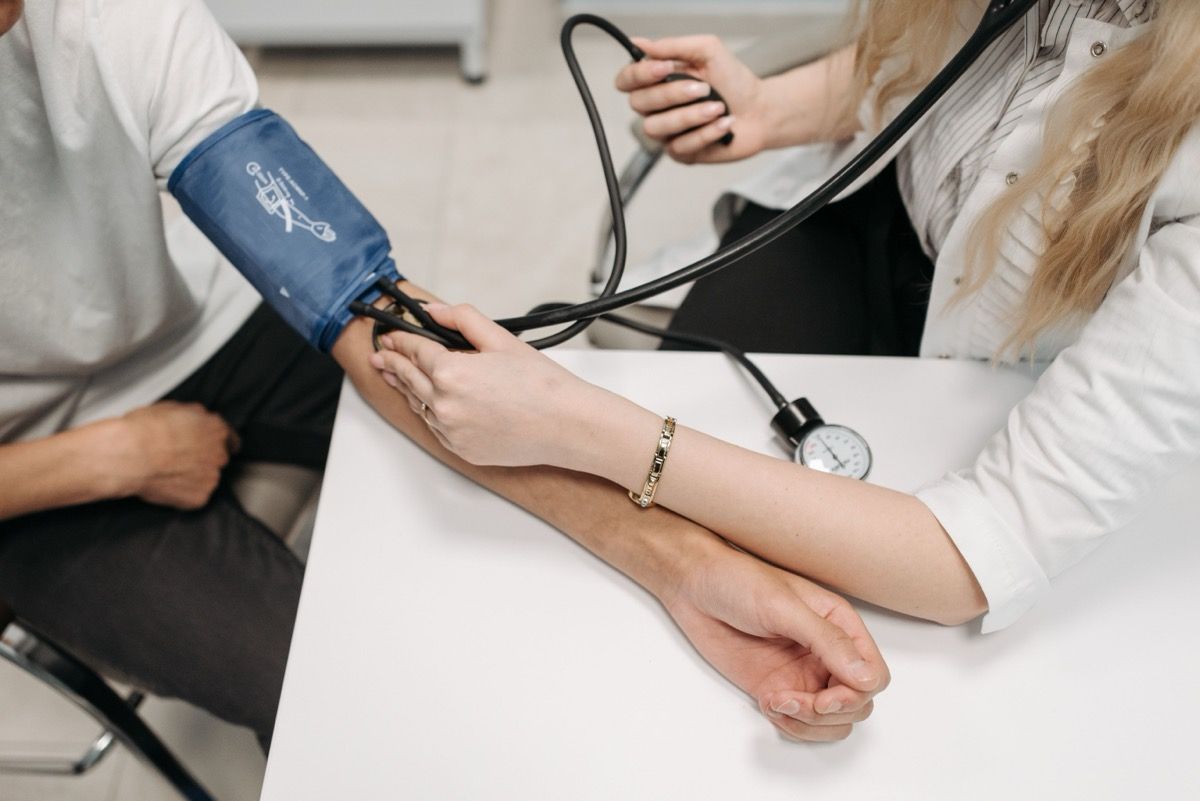 Medical worker taking blood pressure with a cuff on a patient’s arm in a clinic setting
