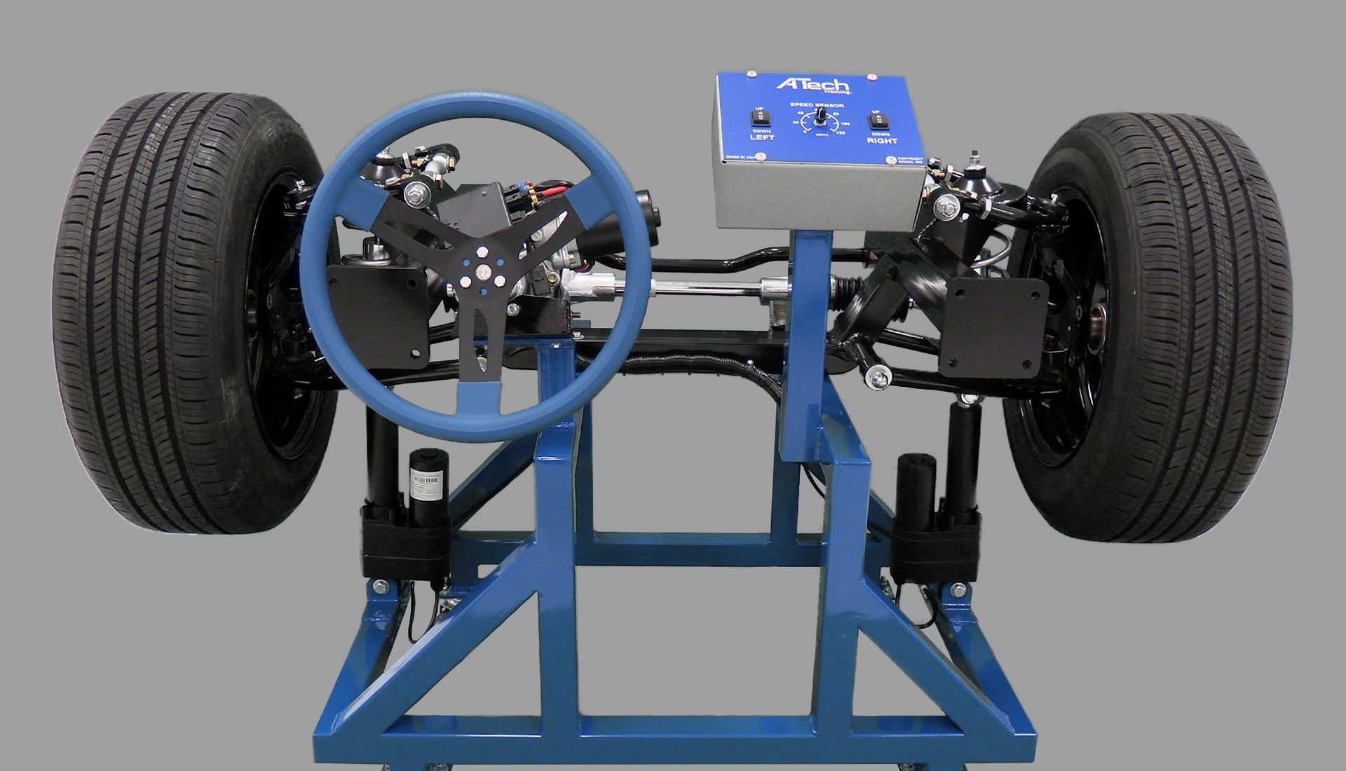 A model of a car with a steering wheel and tires on a stand.