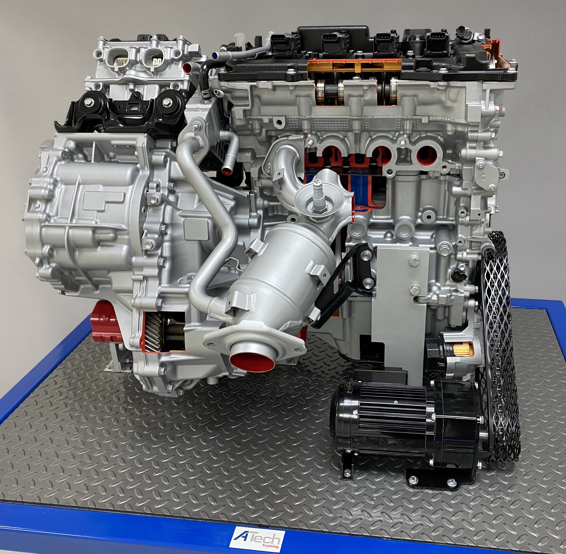 A model of a car engine sits on a blue tray