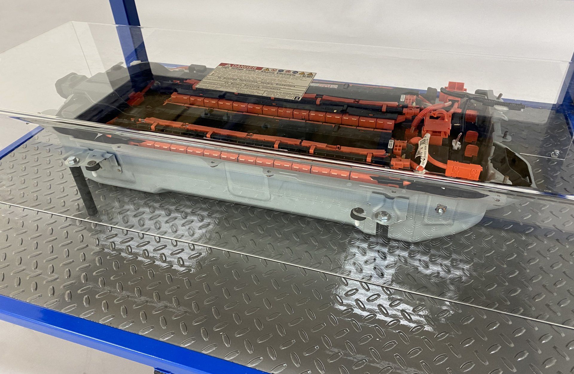 A model of a boat is sitting on top of a metal shelf.