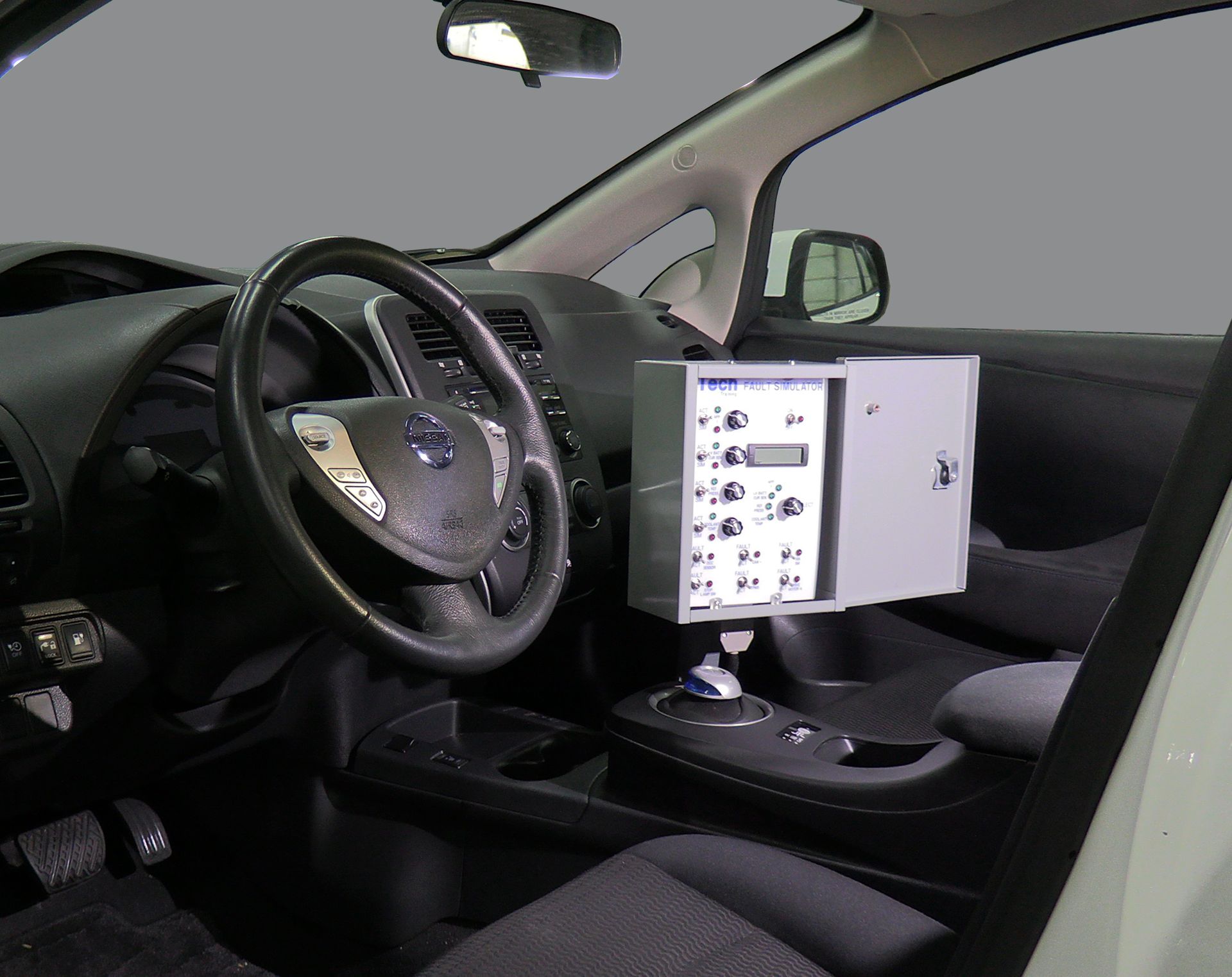 The inside of a car with a box mounted to the steering wheel