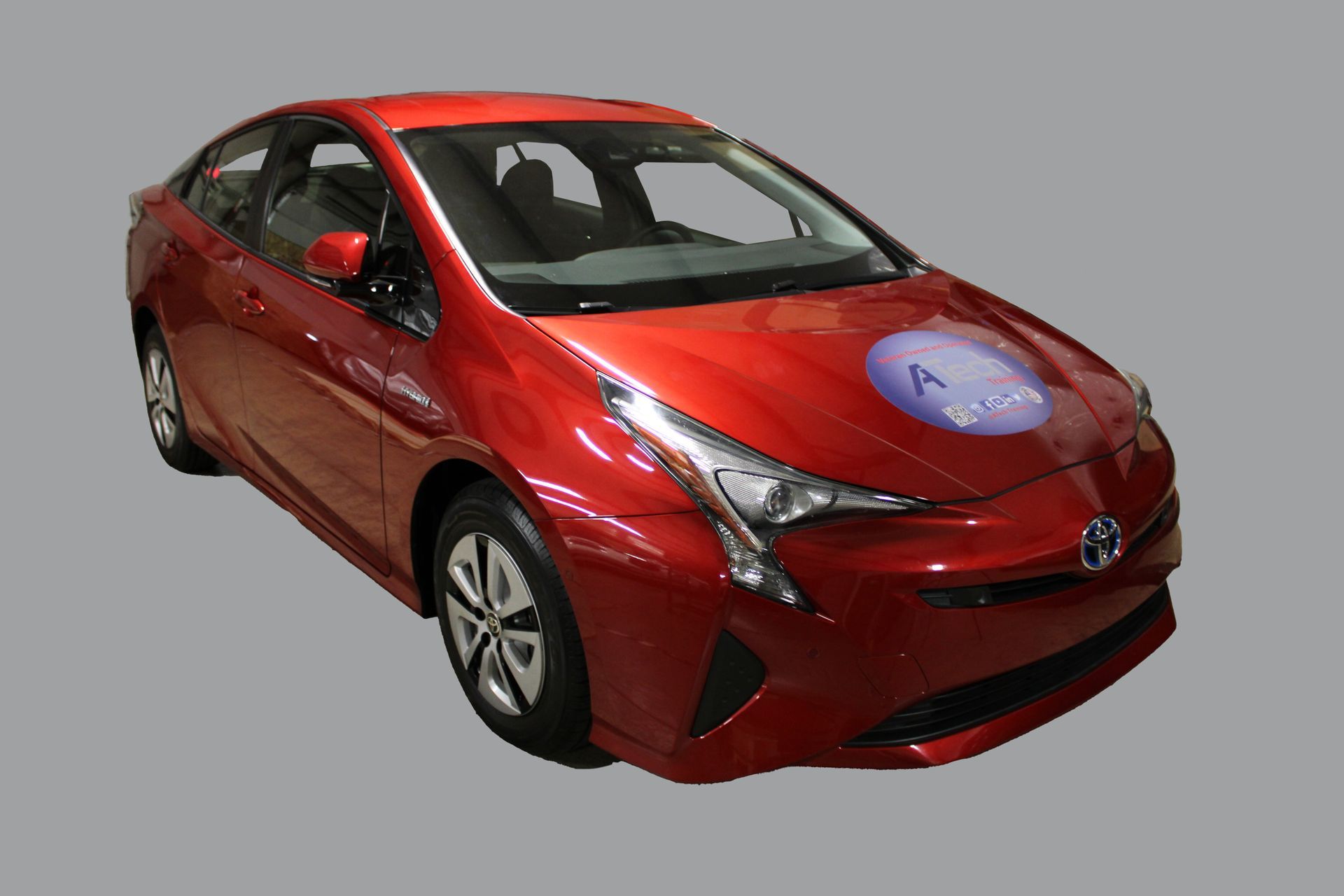 A red toyota prius is on a gray background.