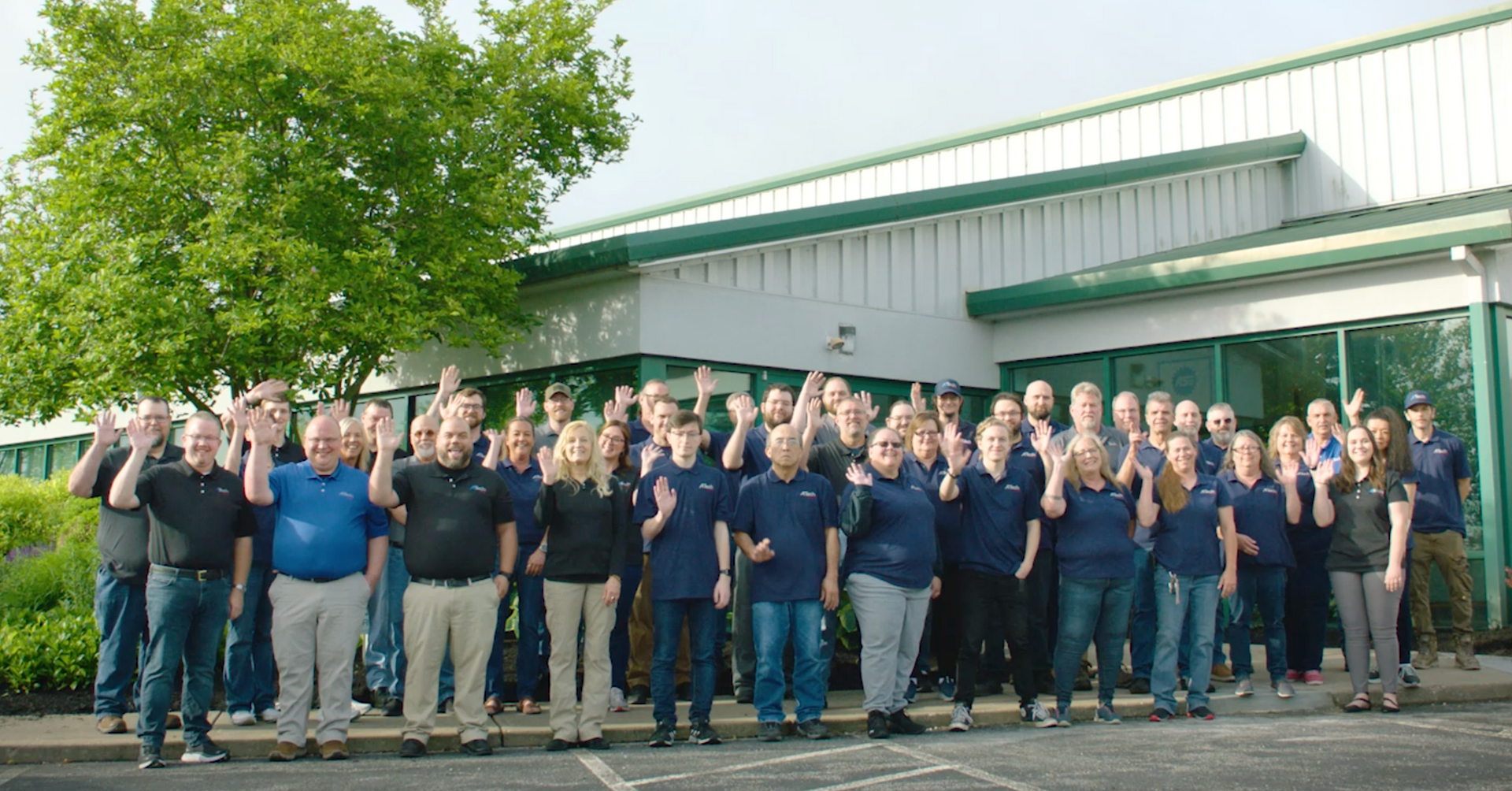 A large group of people are posing for a picture in front of a building.