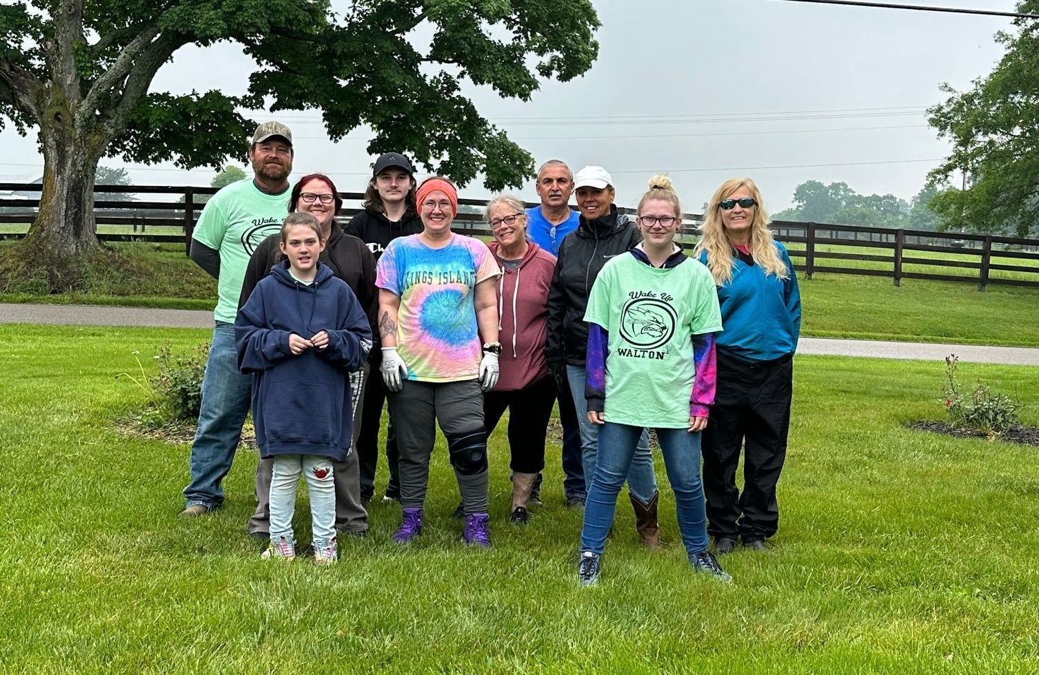 A group of people are posing for a picture in a grassy field.