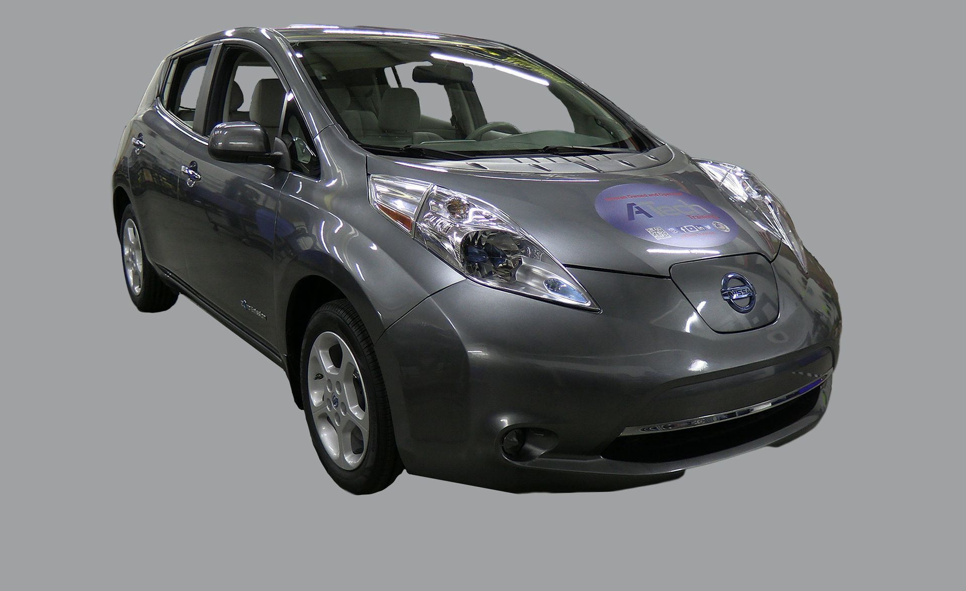 A gray nissan leaf electric car on a gray background