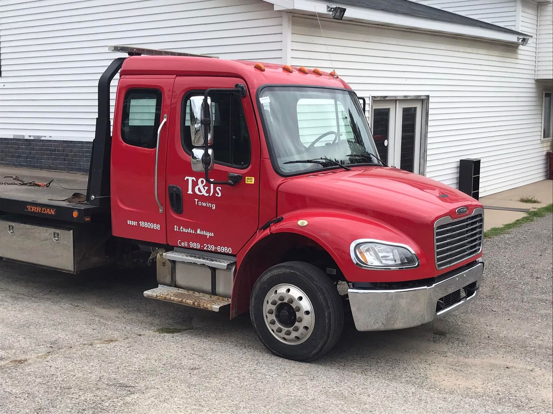Red off-road truck climbing a rocky dirt trail, tilted on a steep incline