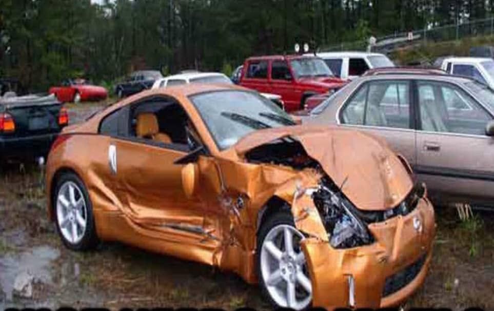 Damaged copper sports car with crushed front end in a parking lot