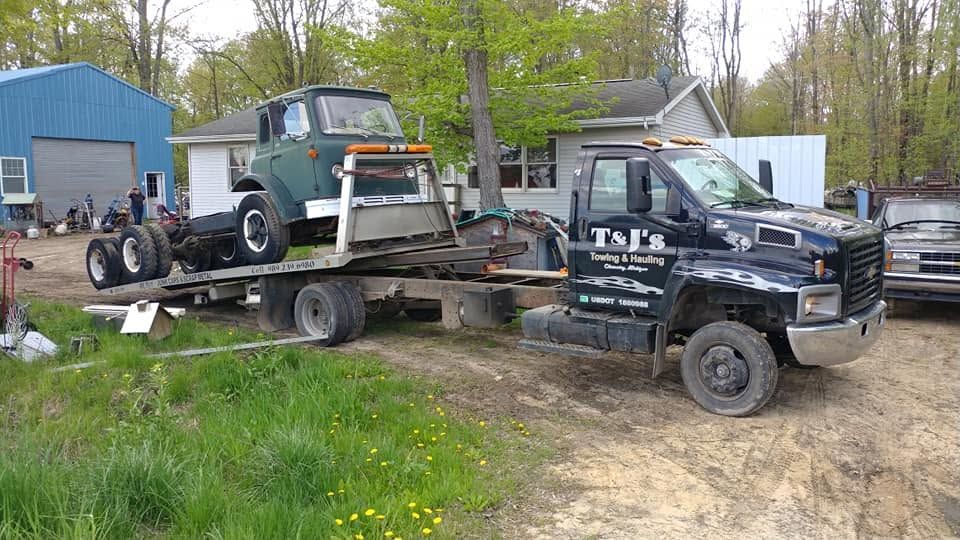 Tow truck at night near memorial sign reading “In loving memory of Tyler”