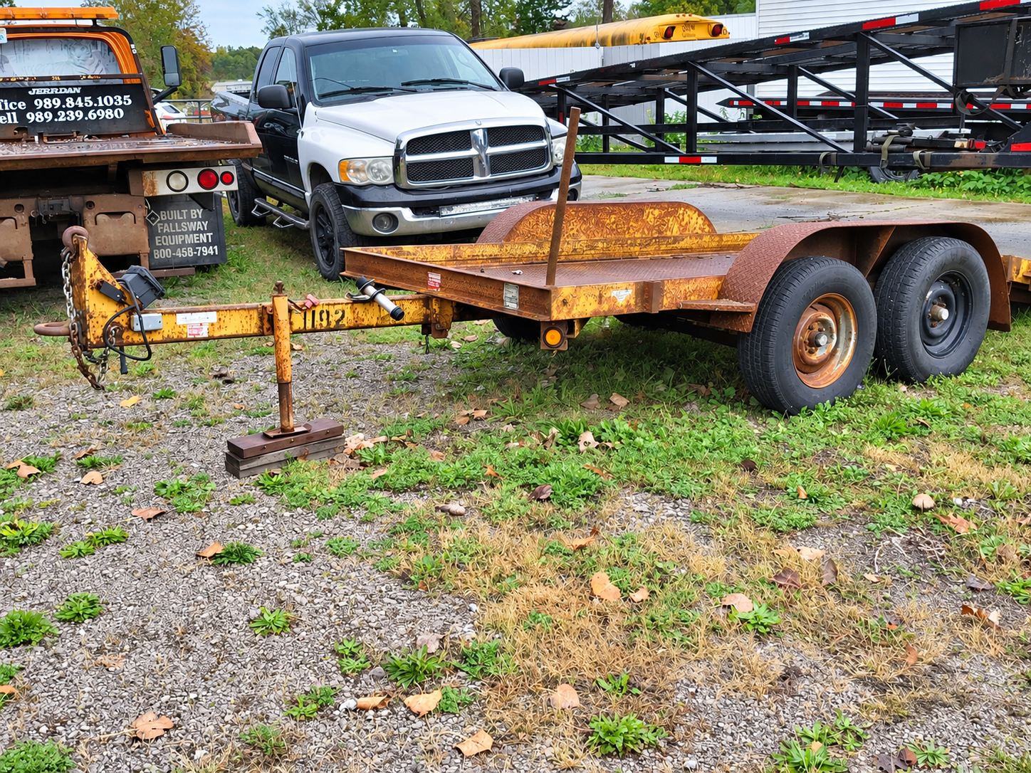 Tow truck hauling a broken-down black SUV on a roadside with two workers nearby