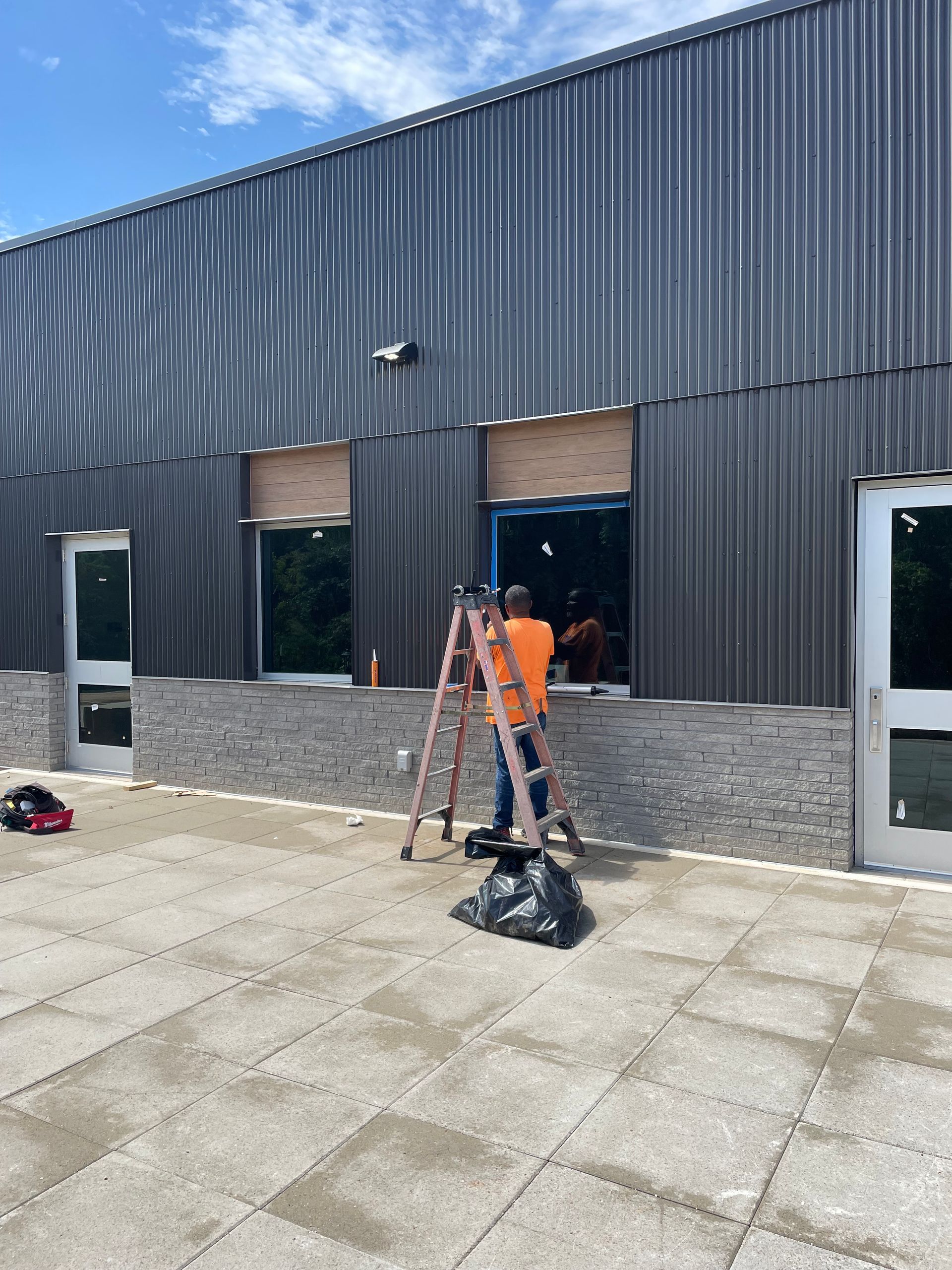 A man is standing on a ladder in front of a building.