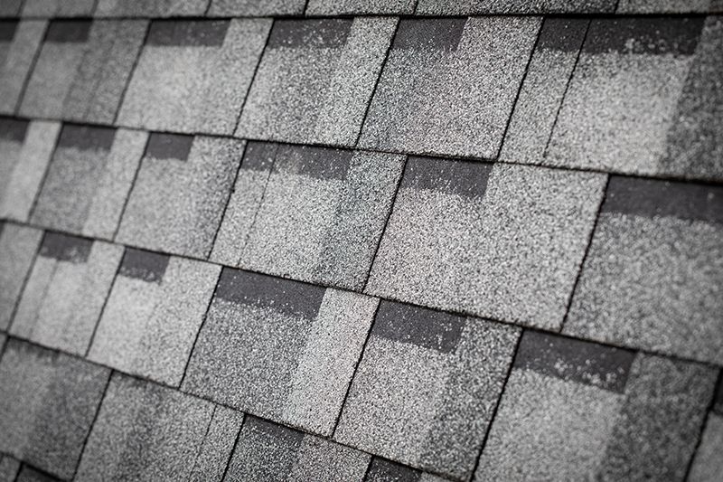 A black and white photo of a roof with shingles.