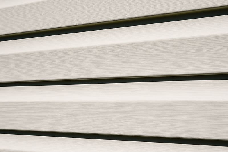 A close up of a white siding with black stripes.