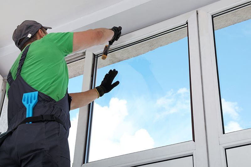 A man is cleaning a window with a brush.