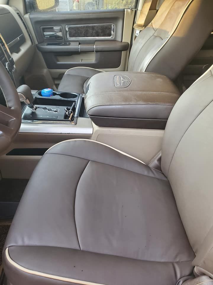 Interior view of a brown and tan leather truck cab with center console, driver seat, and dashboard.