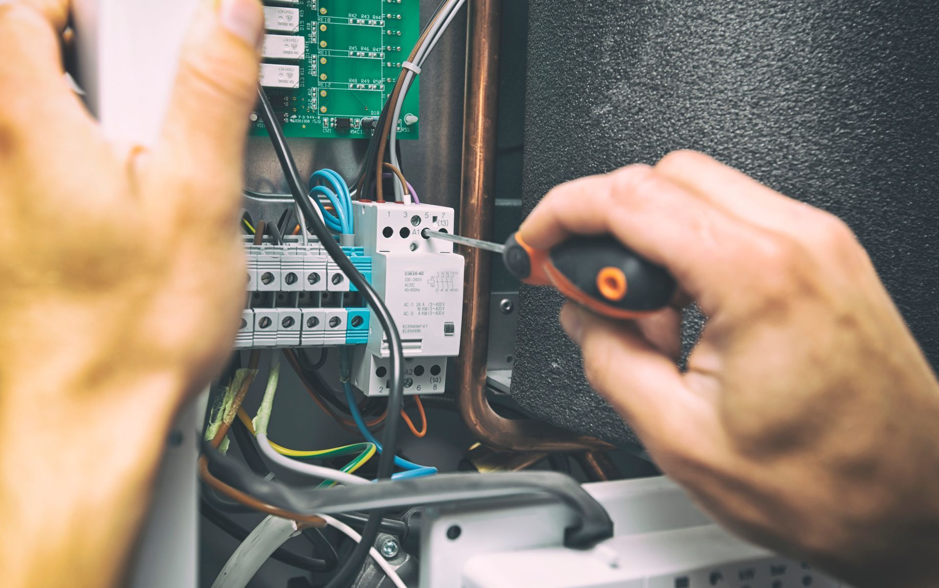 A man is installing the electrical equipment in the house.