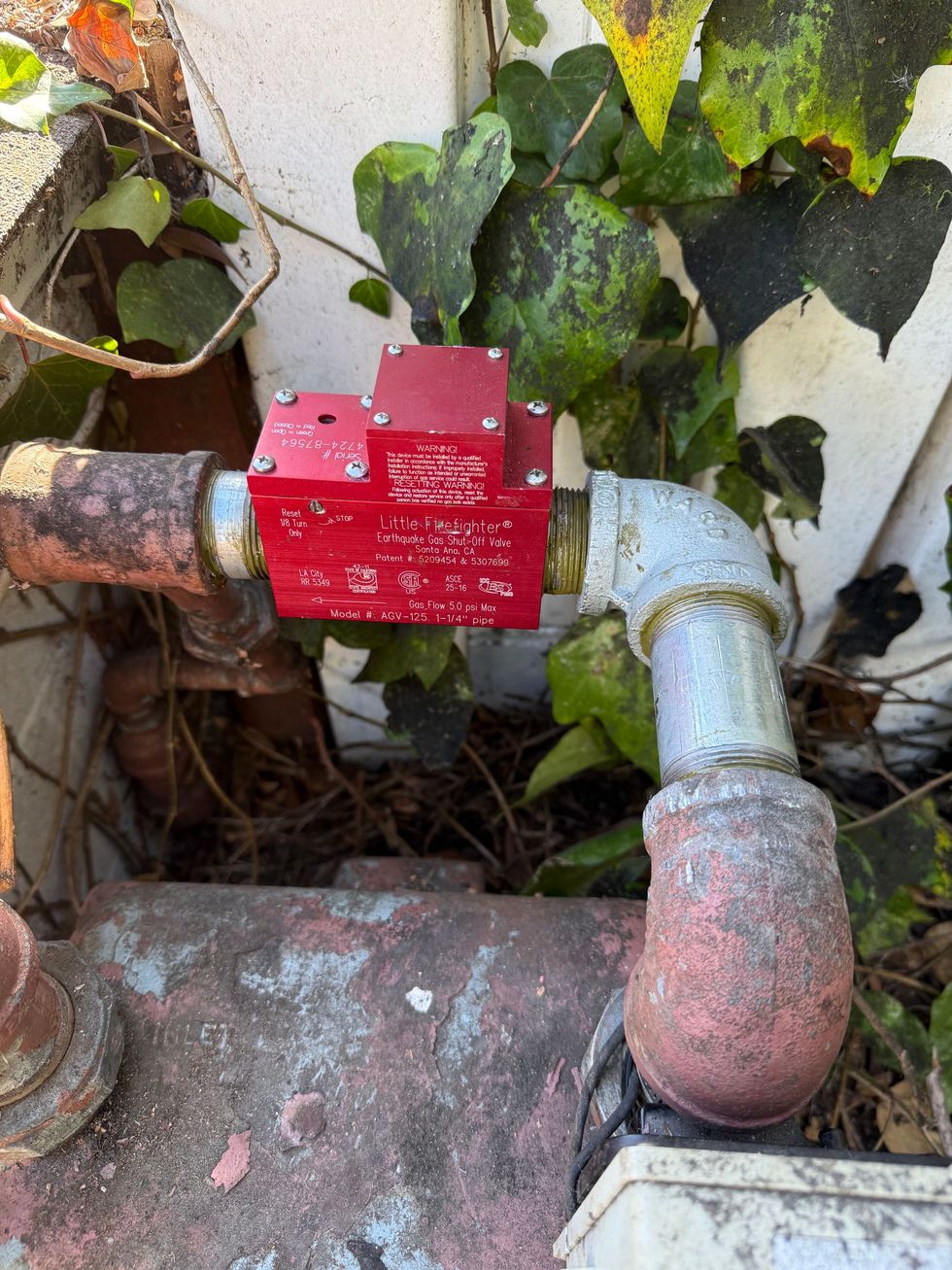 Air conditioning units with toolbox and gloves in backyard.