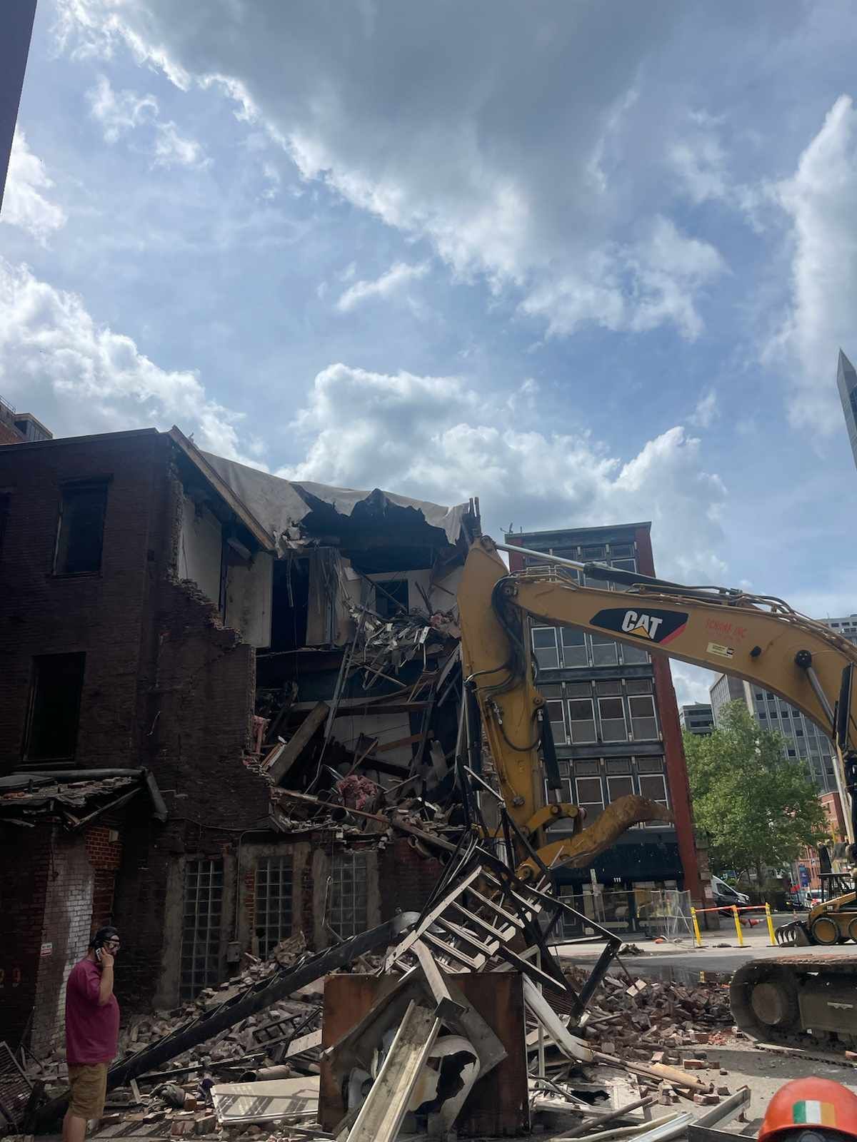excavator demolishing a large residential buildng