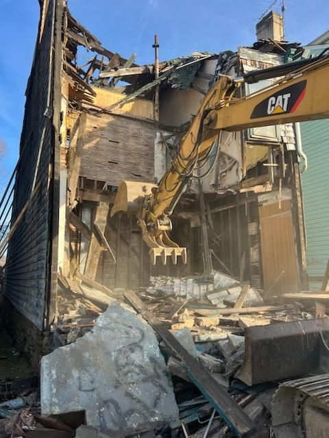 excavator tearing down a house