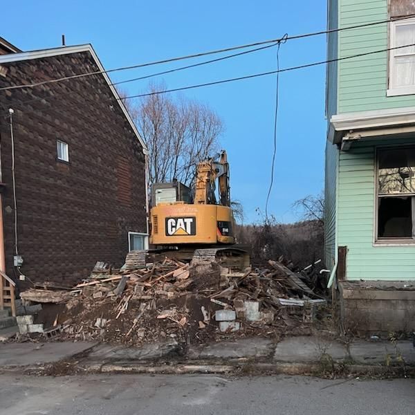 excavator perched on rubble