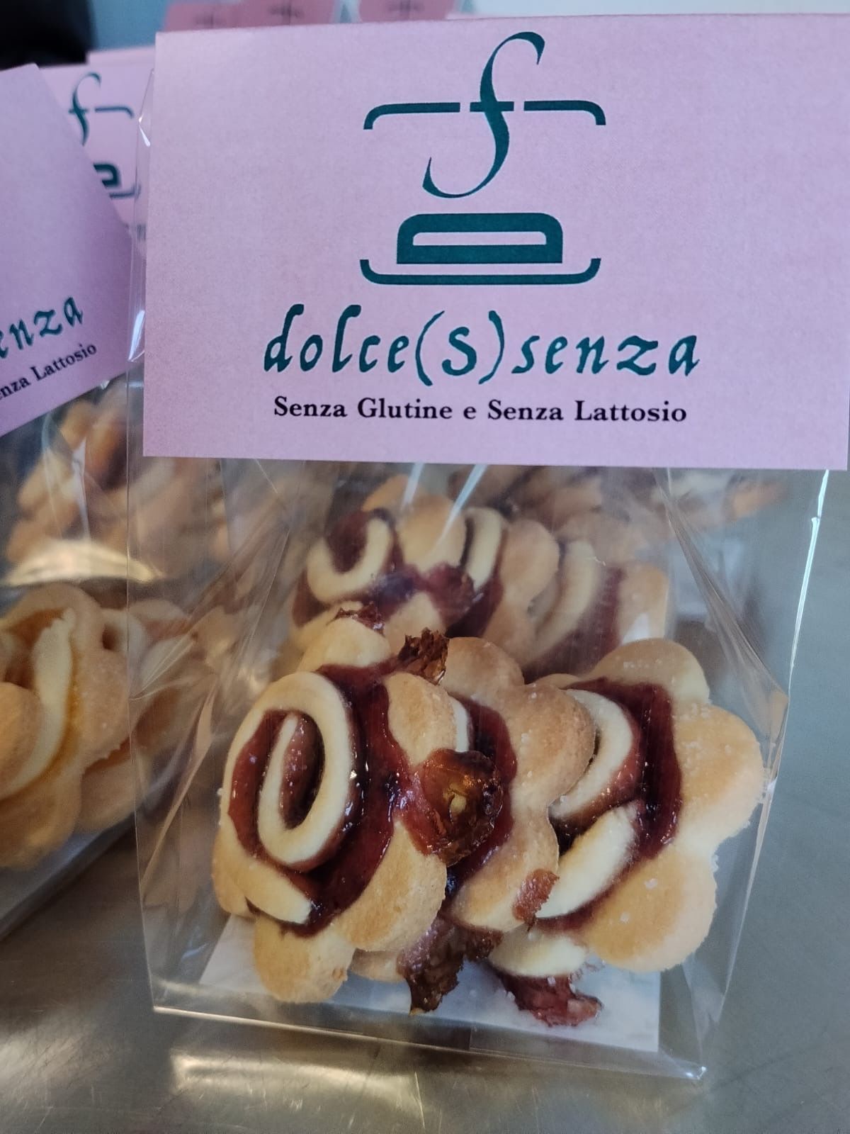Sacchetto trasparente di biscotti rotondi con l’etichetta “dolce(s)enza” e un cartello rosa dietro做爰片