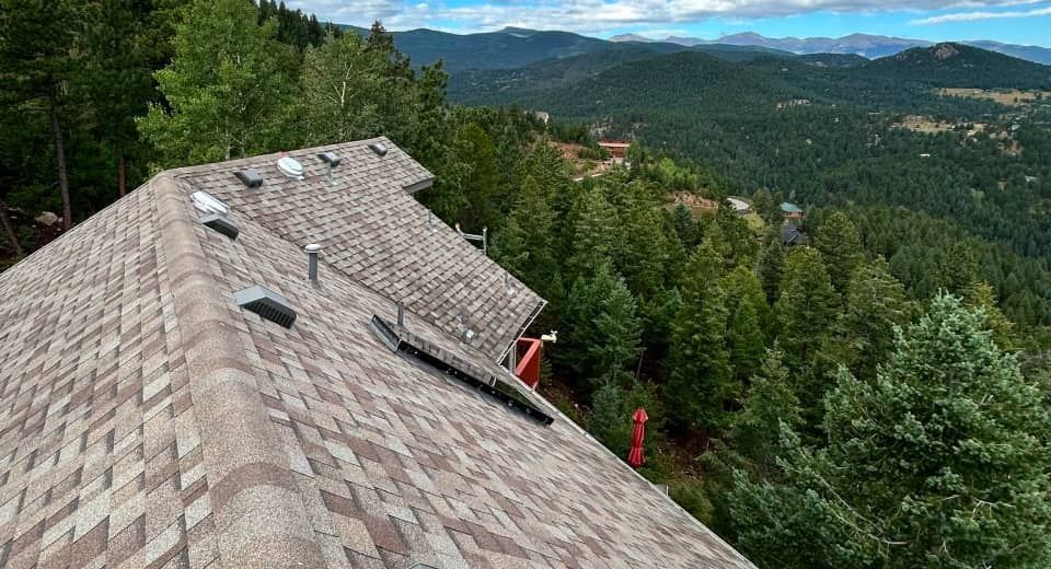 Roof overlooking a forested mountain valley under a cloudy sky