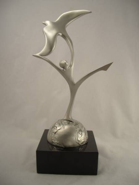 a statue of two birds flying over a person on a black base