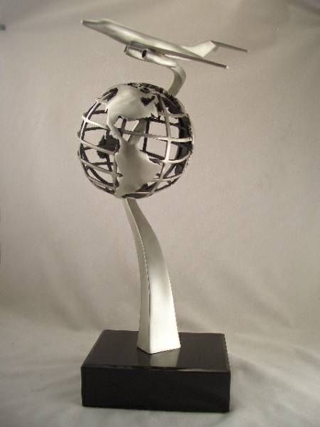 a statue of a plane flying over a globe