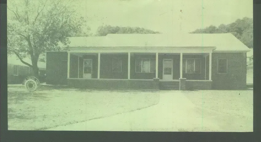 Single-story house with porch and attached garage, viewed from a snowy yard.