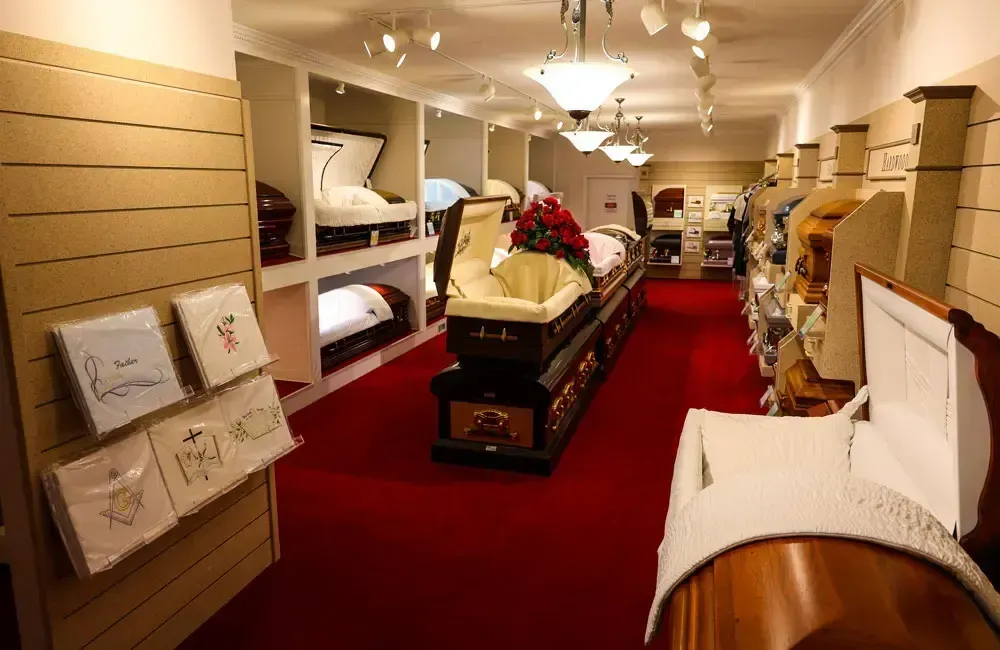 Interior of a carpeted furniture showroom with sofas, tables, and red carpet aisle