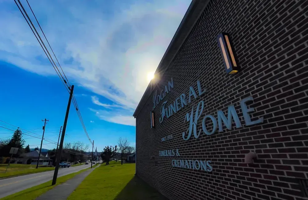 Brick school building with “J. W. Jones” sign beside a road under a blue sky
