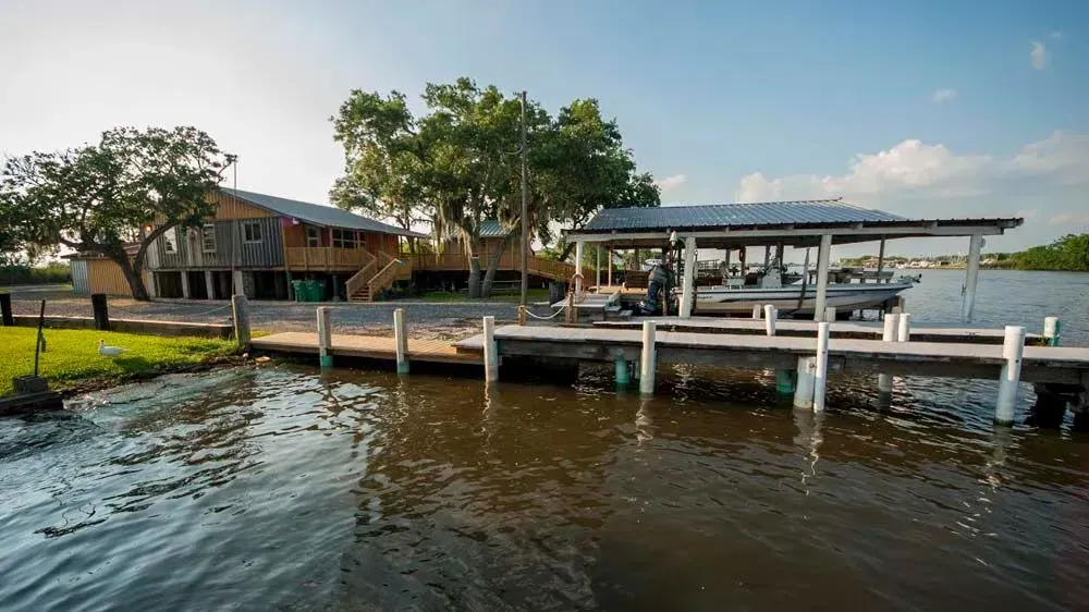 A boat is docked at a dock next to a house on a lake.