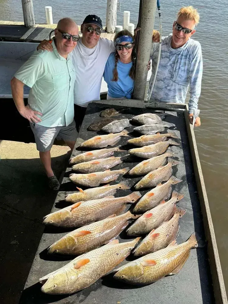 A group of people standing next to a table filled with fish.