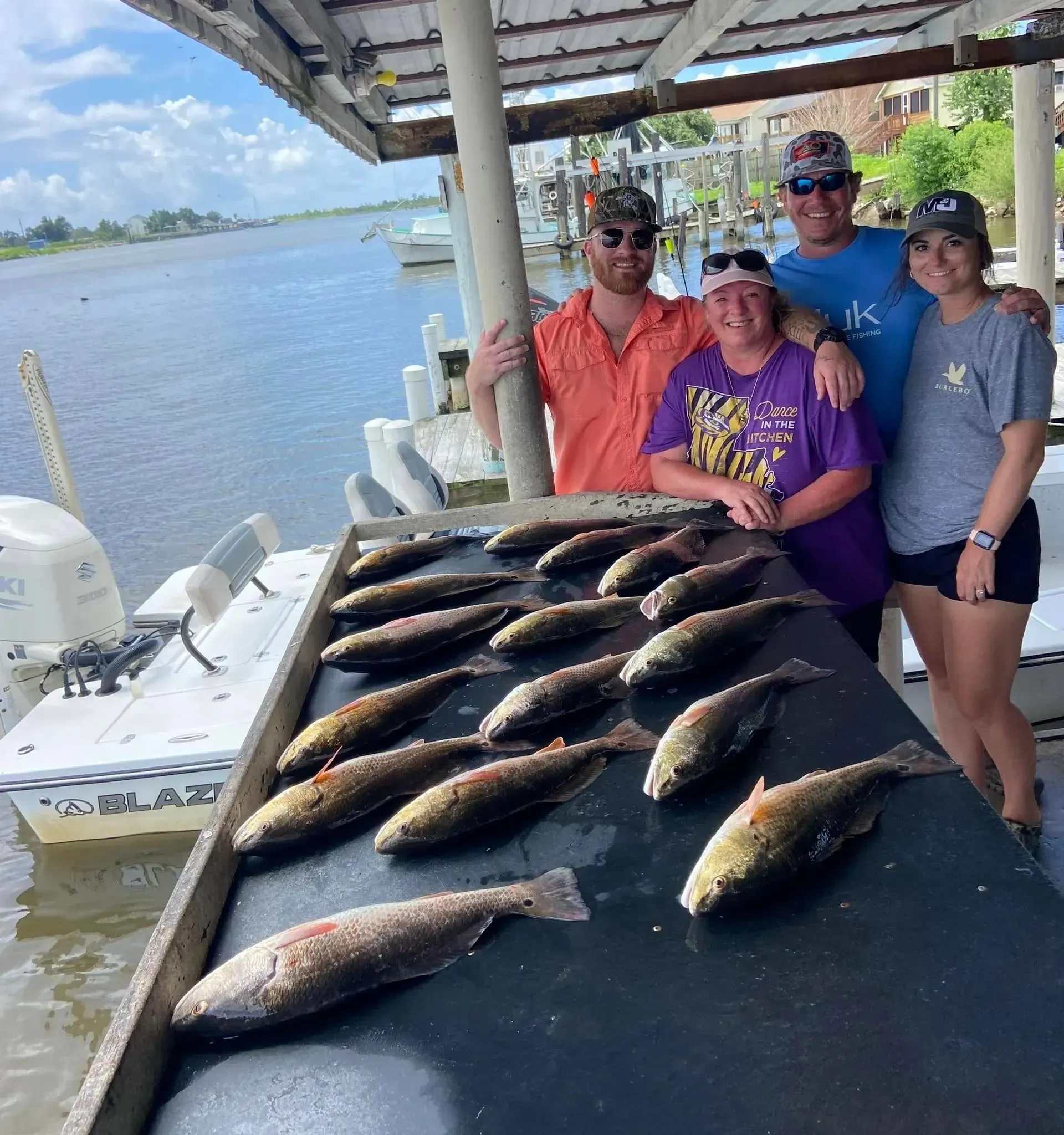 A group of people standing around a table full of fish.