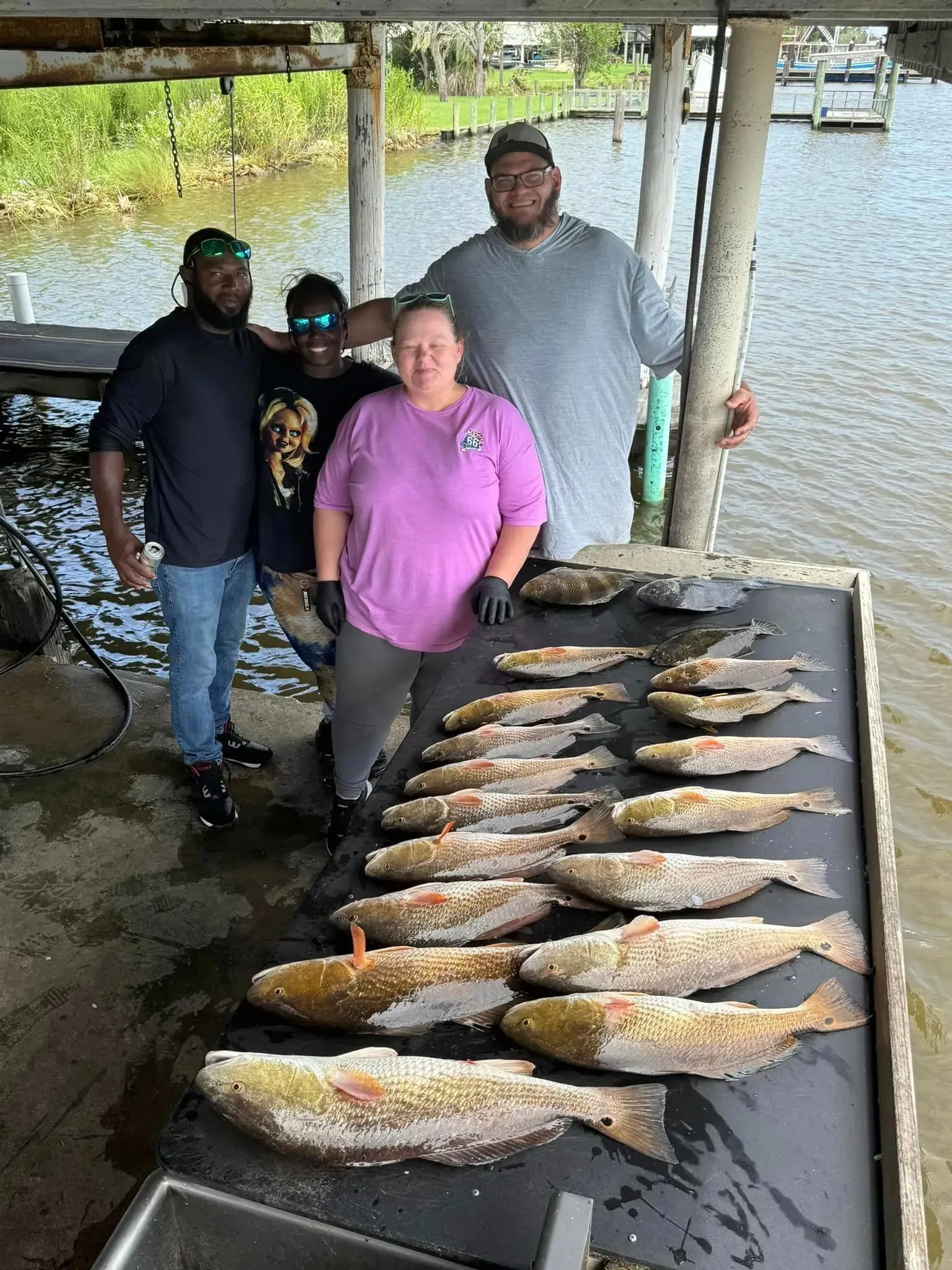 A group of people standing next to a table full of fish.