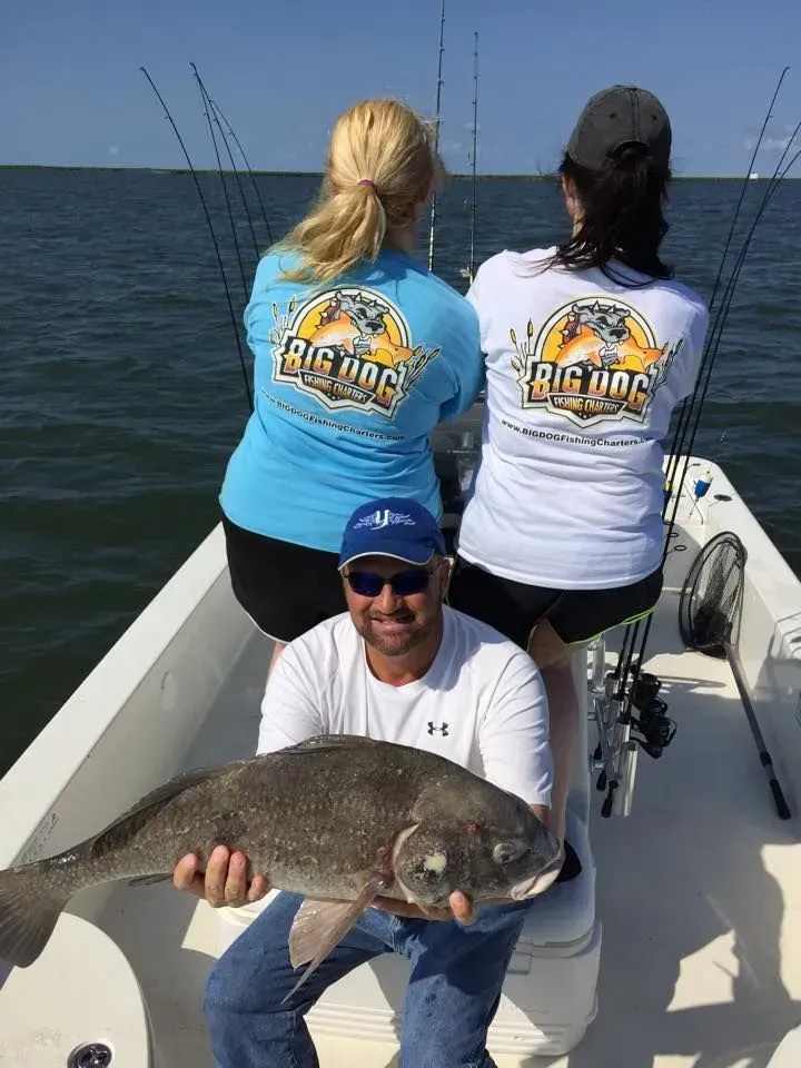A man is sitting on a boat holding a large fish.