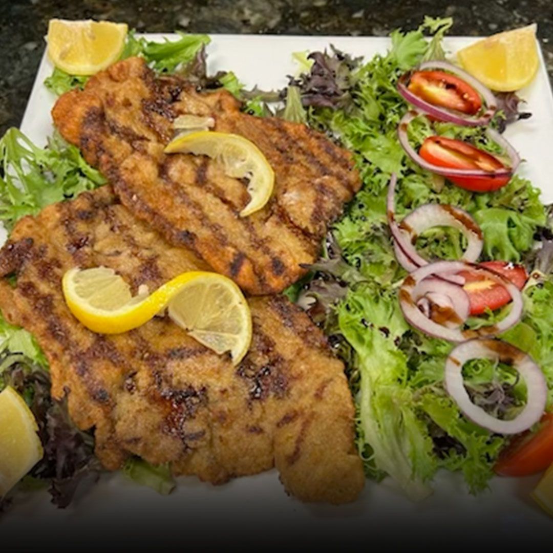Breaded chicken cutlet with lemon and mixed greens at Edison Pizza in Edison NJ