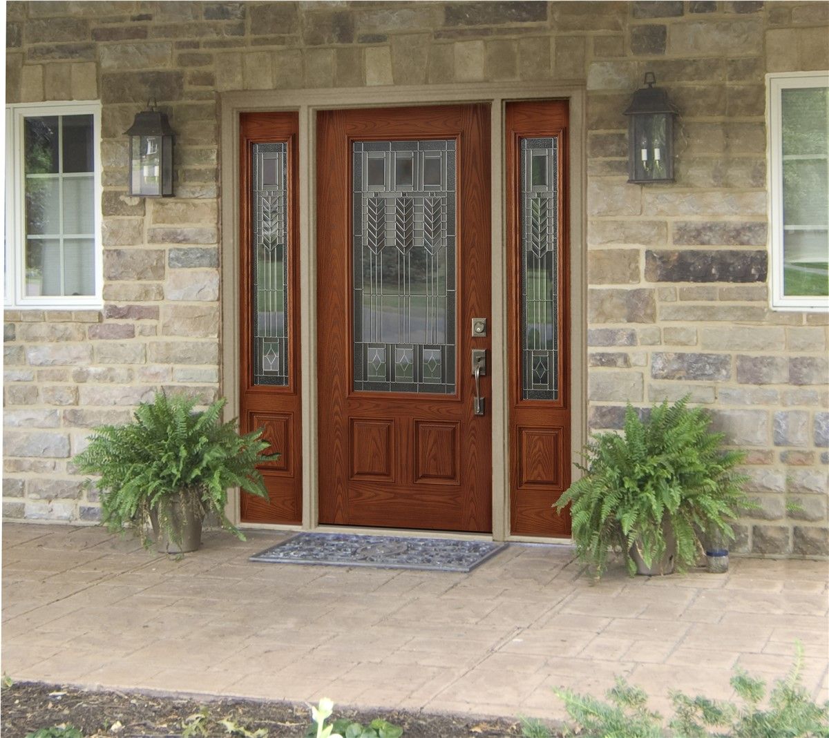 Wooden front door with sidelights and decorative glass panel, set in a stone facade. Ferns flank the entrance.