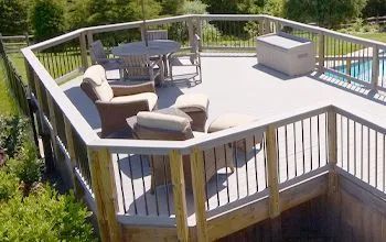 Wooden deck with outdoor furniture next to a pool.