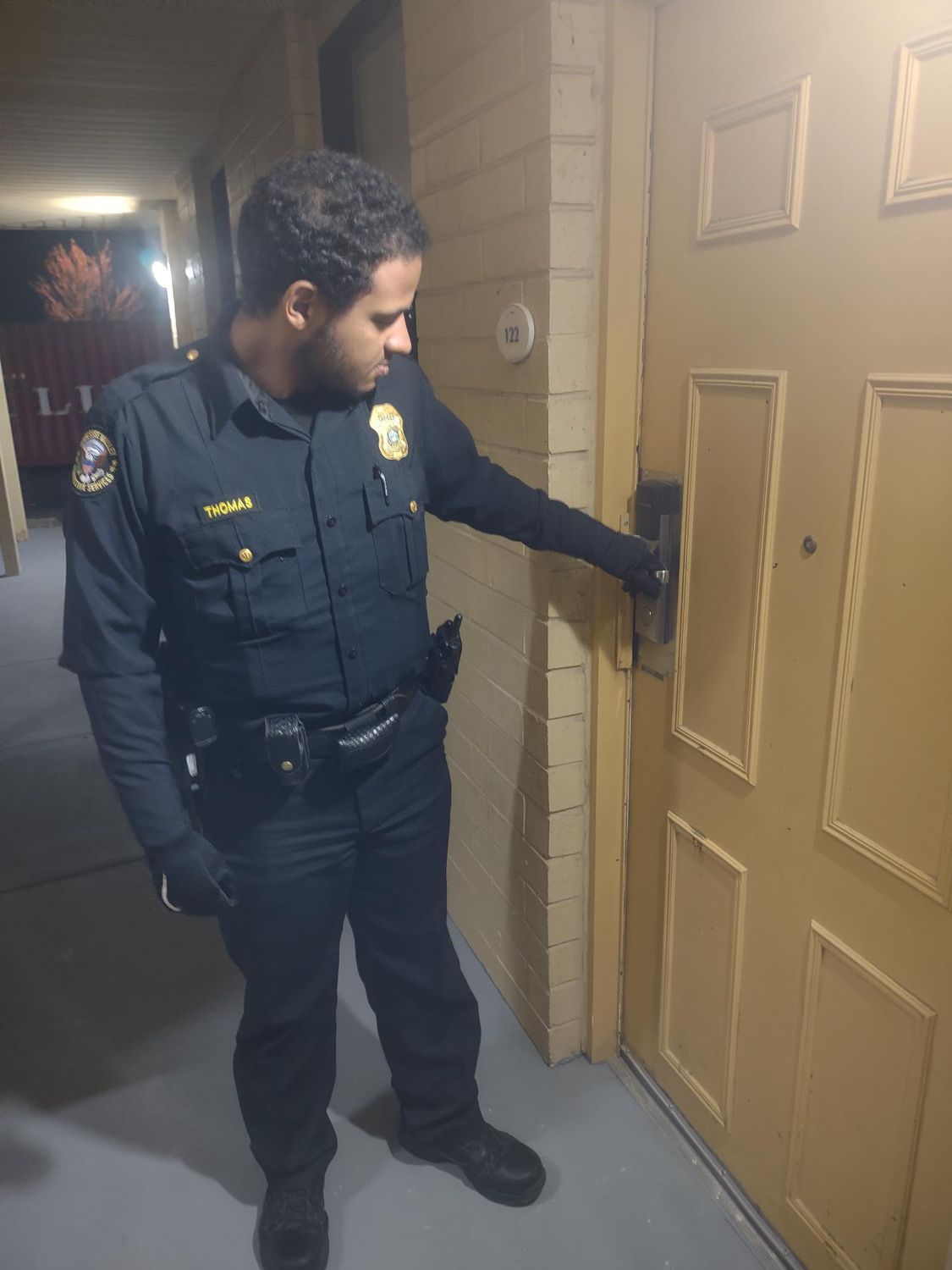 a security officer is inspecting a door in a hallway
