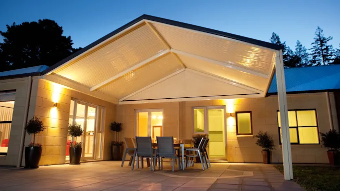 A Brick House With a Patio With Wicker Furniture and a Pergola —In The Central Coast