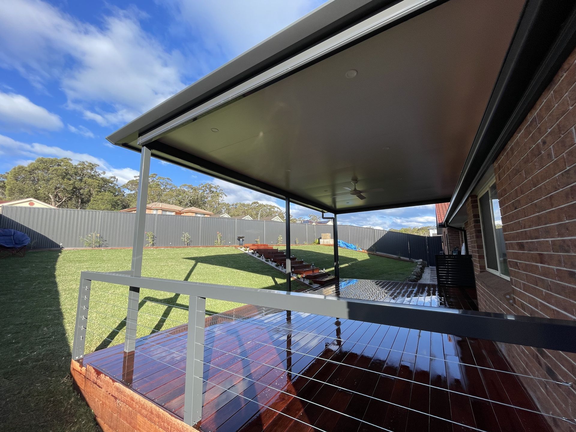 A Patio With Furniture and a Fireplace Under a Wooden Roof — Outdoor Leisure Living In Wyong, NSW