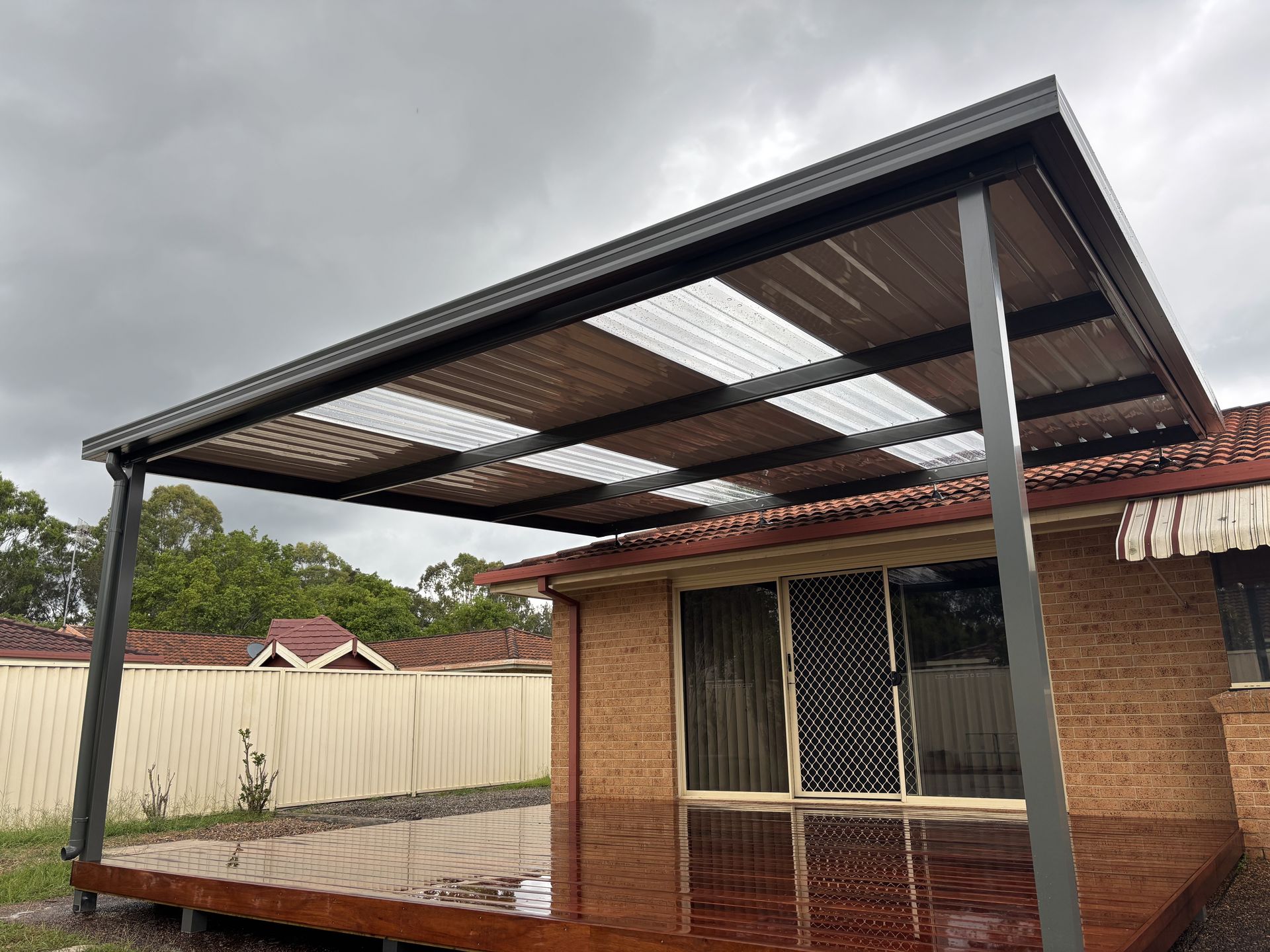 A Man is Using a Drill on a Wooden Deck — Outdoor Leisure Living In Tuggerah, NSW