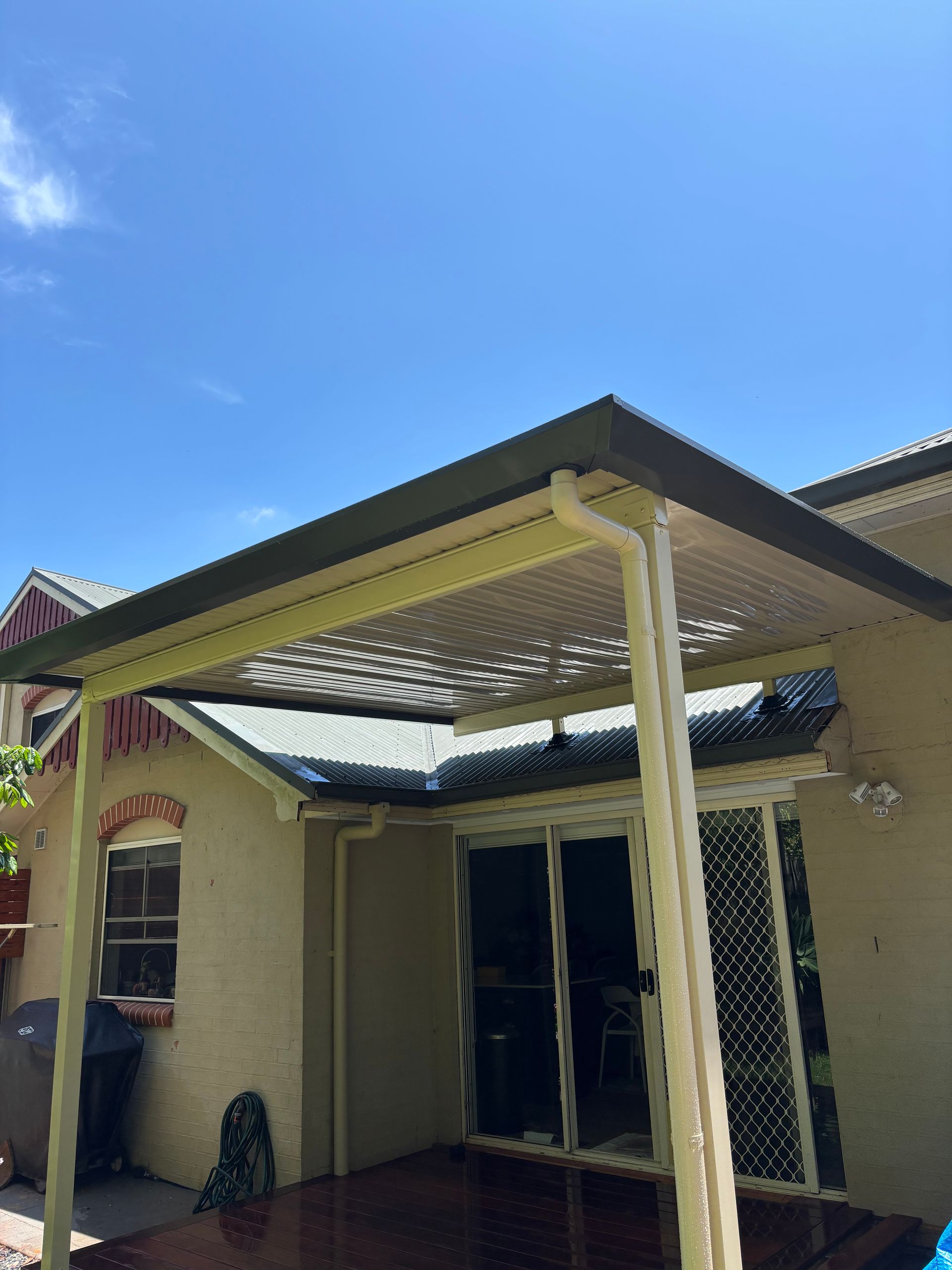 Patio With Pergola Roof Attached to a Beige House — In The Central Coast
